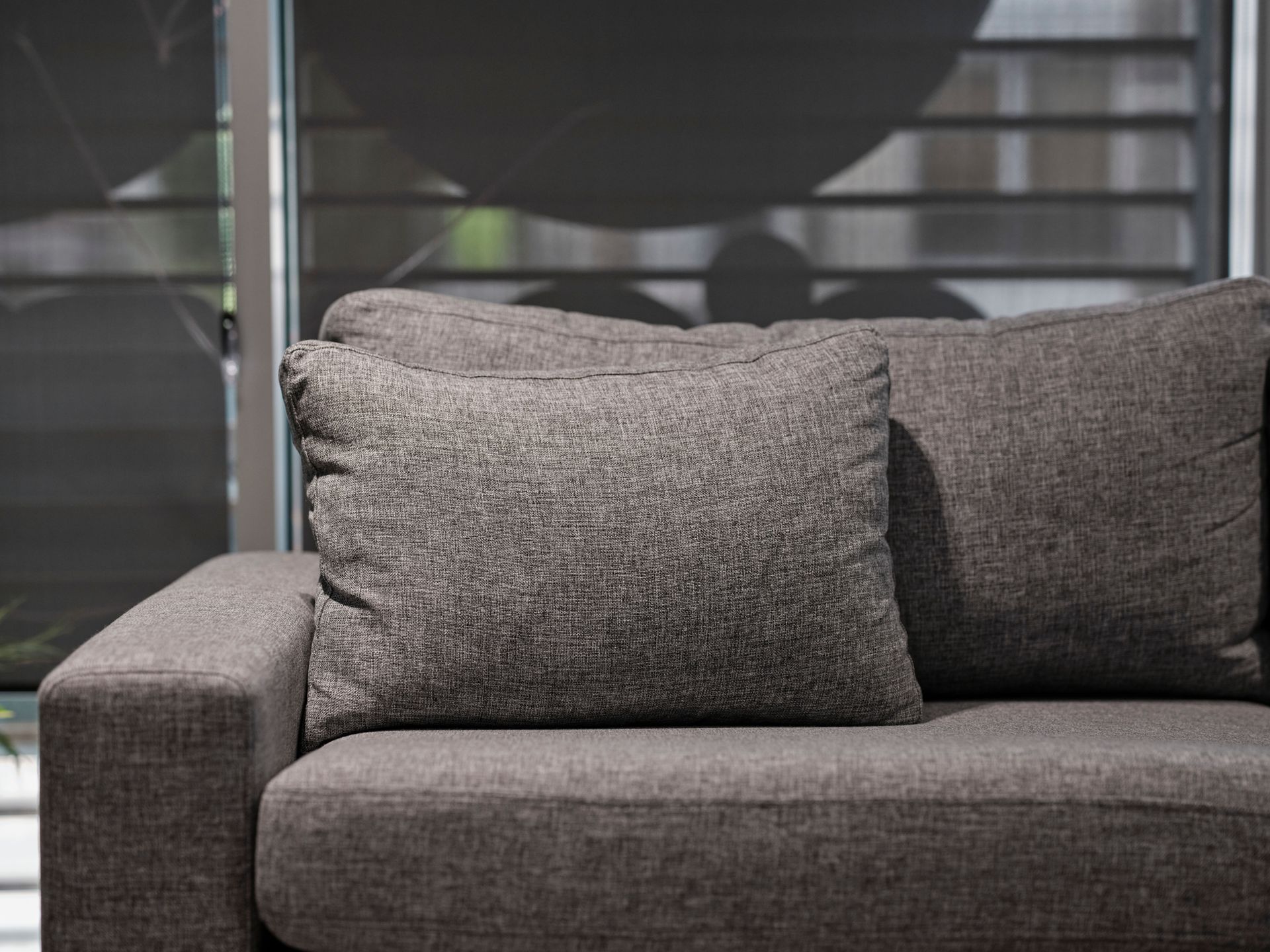 Elegant grey sofa with plush cushions in a contemporary living room setting.